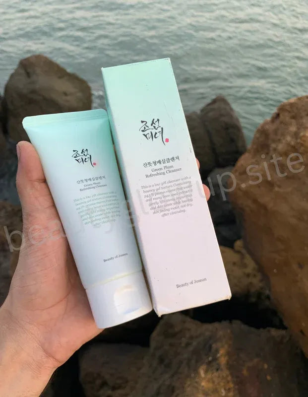 Two skincare products held by a hand with a natural background