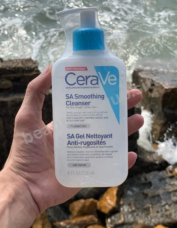 CeraVe SA Smoothing Cleanser bottle held in a hand with a natural background