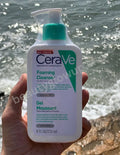 CeraVe foaming cleanser held in front of a body of water