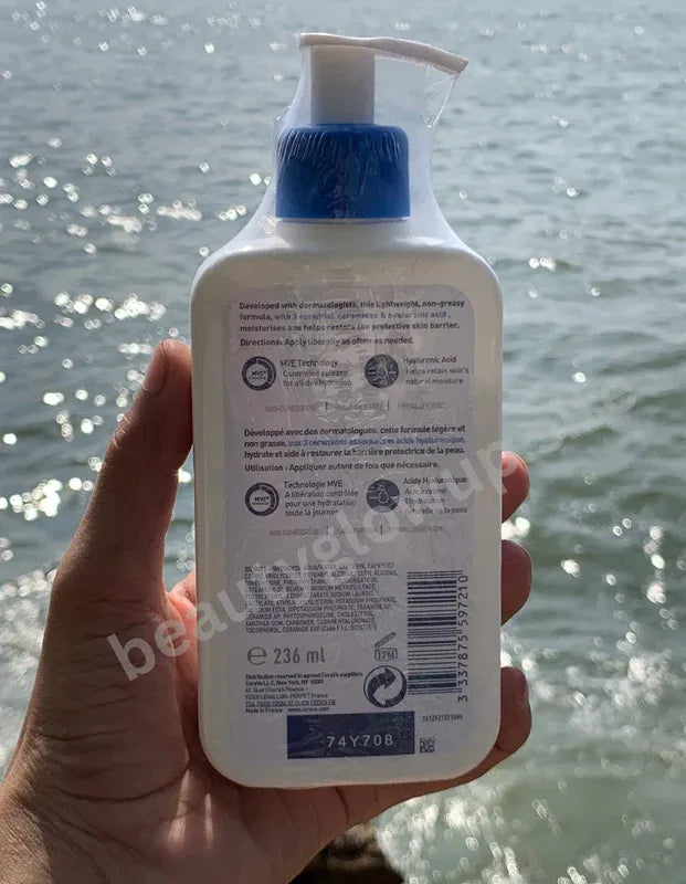 CeraVe moisturizing lotion held in a hand with water in the background