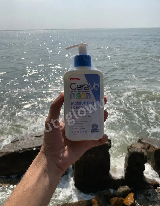 CeraVe moisturizing lotion held by a hand with ocean in the background