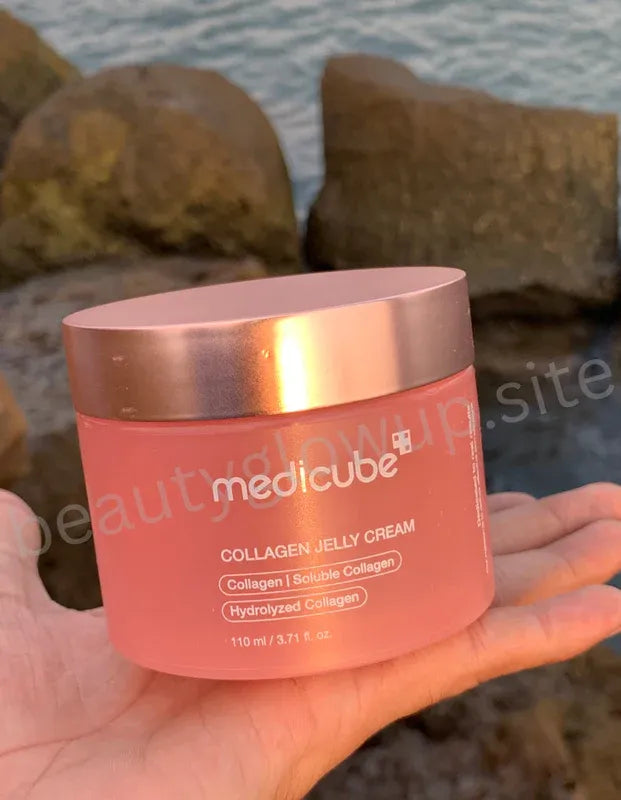 Medicube Collagen Jelly Cream jar held by a hand with a blurred natural background